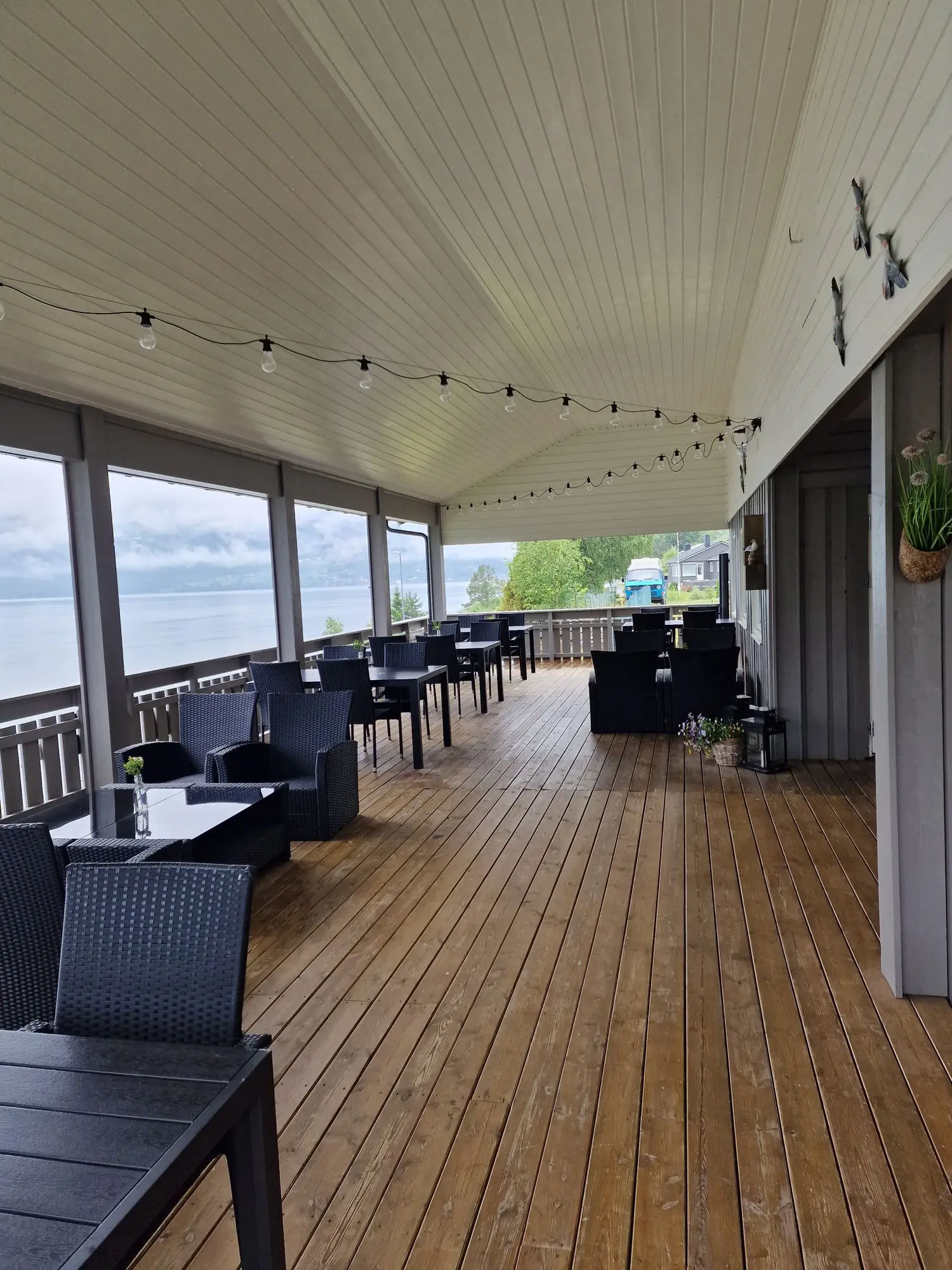 Restaurant terrace with string lights and fjord view